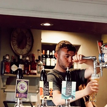 dyn yn tollti peint tu nol i'r bar yn whilehall